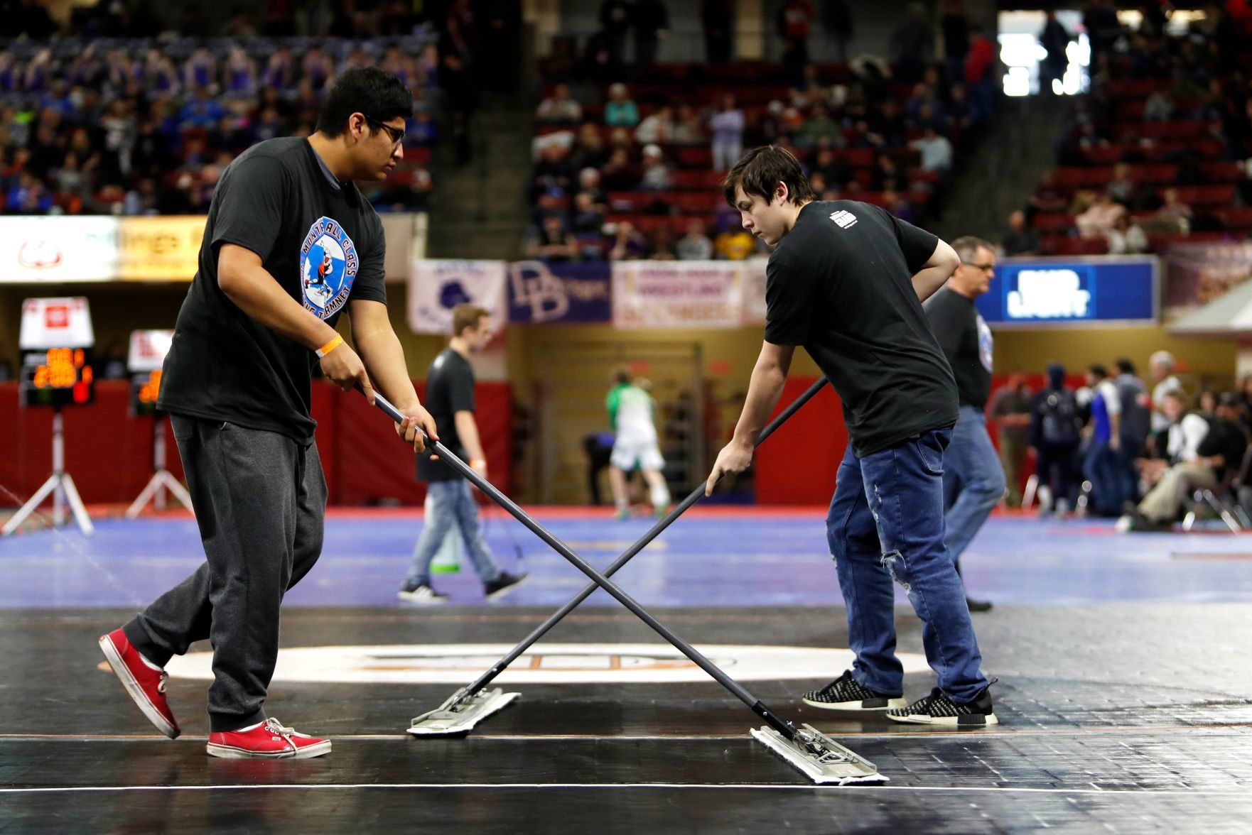 Assistants clean the mats